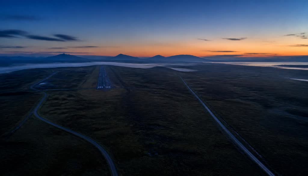 A remote airfield and open terrain at dawn with two ground tracks diverging